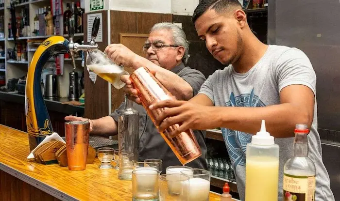 dos personas preparando cocteles