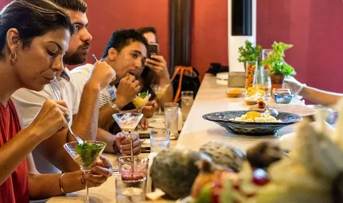 varias personas comiendo en una mesa